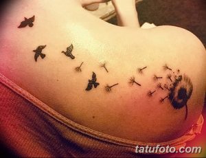 Фото тату одуванчика, из которого вылетают птицы, на плече. Изящный рисунок в черных тонах, символизирующий свободу и мечты.