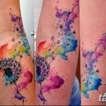 Фото акварельных татуировок одуванчиков на руке. Разноцветные, яркие рисунки, выполненные в технике акварели. Эскизы тату, символизирующие легкость и красоту.