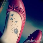 Фото минималистичной татуировки одуванчика с летящими птицами на стопе, выполненной в черном цвете с акцентом на легкость и свободу.