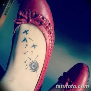 Фото минималистичной татуировки одуванчика с летящими птицами на стопе, выполненной в черном цвете с акцентом на легкость и свободу.