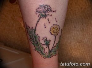 Фото яркой татуировки одуванчика с летящими ключиками и небольшими фигурками людей на ноге, выполненной в мультяшном стиле.