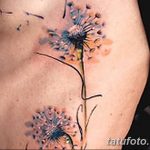 Фото акварельной татуировки одуванчика на боку, выполненной в нежных пастельных тонах с эффектом размытости и легкости.