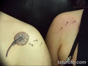 Фото тату одуванчика на плече. Небольшой черно-серый рисунок с летящими семенами. Минималистичный эскиз тату для девушек.