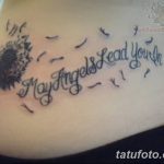 Татуировка одуванчика с летящими семенами и надписью "May Angels Lead You In" на боку. Изображение выполнено в черном цвете.