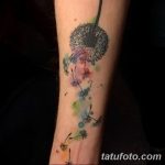 Фото татуировки одуванчика на руке, выполненное в акварельной технике с использованием ярких цветов и оттенков.