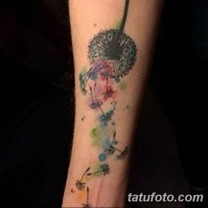 Фото татуировки одуванчика на руке, выполненное в акварельной технике с использованием ярких цветов и оттенков.