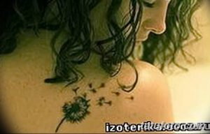 Фото тату одуванчика на плече, выполненное в черно-белой гамме. Простой и элегантный рисунок с акцентом на детали семян.