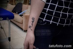 Фото тату одуванчика на запястье в стиле минимализм. Черно-белый рисунок с четкими линиями и детальной проработкой семян.
