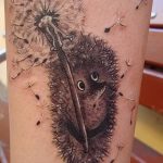 Фото реалистичной татуировки одуванчика с ежом на руке. Детальный рисунок татуировки в черно-белой гамме.