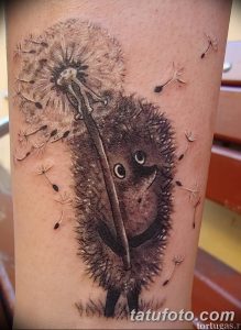 Фото реалистичной татуировки одуванчика с ежом на руке. Детальный рисунок татуировки в черно-белой гамме.