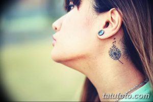 Фото миниатюрной татуировки с изображением одуванчика, расположенной за ухом девушки.