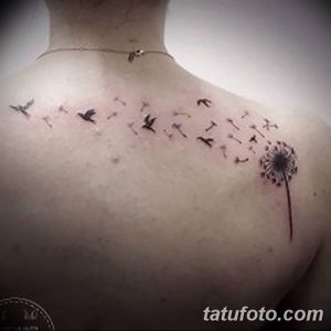 Фото тату одуванчика на спине. Изображение выполнено в черном цвете, с акцентом на летящие пушинки, образующие узор.