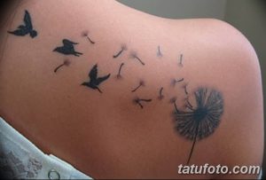 Фото татуировки одуванчика с улетающими птицами на плече. Черно-белый рисунок татуировки, выполненный в минималистичном стиле, выглядит очень нежно и изящно.