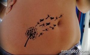Фото тату одуванчика с разлетающимися семенами, расположенного на животе. Минималистичный дизайн, выполненный в черном цвете, подчеркивает изящество рисунка.