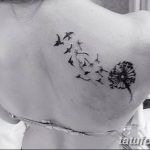 Фото татуировки на плече с изображением одуванчика, из которого вылетают птицы, выполненное тонкими черными линиями в минималистичном стиле.