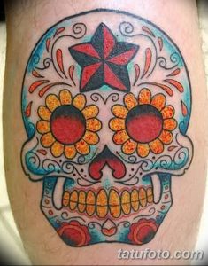 Фото тату черепа в стиле сахарной смерти (Sugar Skull) с яркими цветами и узорами на руке. Красочный рисунок татуировки для девушек.