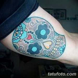 Фото тату черепа с цветами, выполненное в стиле минимализм на руке. Простой и элегантный рисунок татуировки.