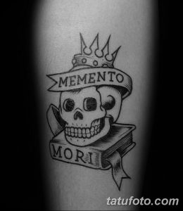 Фото простой татуировки с изображением короны, черепа и надписи 'Memento Mori' на руке. Лаконичный дизайн, четкие линии.
