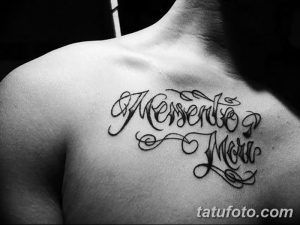 Фото татуировки с надписью 'Memento Mori' на груди. Изящный шрифт, плавные линии и декоративные элементы.