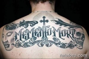 Фото татуировки на спине с надписью 'Memento Mori', черепом, крестом и декоративными элементами.