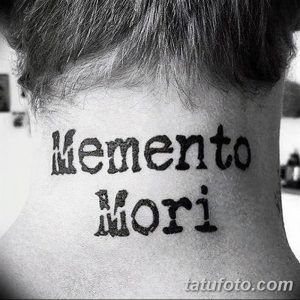 Фото минималистичной татуировки на задней части шеи с надписью 'Memento Mori', выполненной простым шрифтом. Черно-белое изображение.