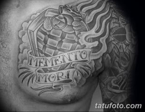 Фото тату черепа с песочными часами и надписью 'Memento Mori' на груди. Черно-белая татуировка с высокой детализацией и мрачной атмосферой.