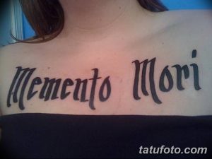 Фото тату с надписью 'Memento Mori' на груди. Простая, черно-белая татуировка с четким шрифтом.