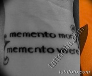 Фото тату с повторяющейся надписью 'Memento Mori' на руке. Минималистичный, черно-белый рисунок татуировки.