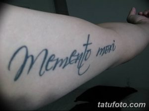 Фото тату: минималистичная надпись 'Memento Mori' на руке, выполненная простым шрифтом в черном цвете.