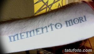 Фото тату с надписью 'Memento Mori', выполненной простым шрифтом на руке. Стильная и минималистичная татуировка, привлекающая внимание своей лаконичностью.