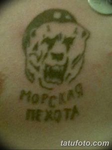Фото тату на руке: простой рисунок черепа в берете морской пехоты с надписью "Морская пехота". Черно-серые тона, минималистичный стиль.