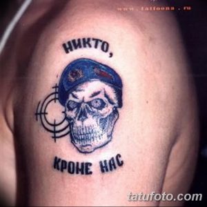 Фото татуировки черепа в берете с надписью "Никто кроме нас" и мишенью, выполненной в сине-белой гамме на плече. Рисунок в стиле милитари.