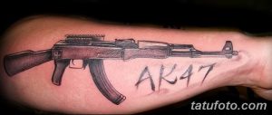 Фото тату автомата с надписью AK47 на руке. Черно-серый рисунок с реалистичной проработкой деталей. Подходит для поклонников легендарного оружия.
