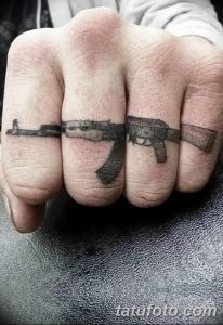 Небольшие черно-серые татуировки автоматов Калашникова на пальцах рук. Оригинальный и смелый дизайн.