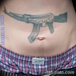 Фото тату автомата Калашникова, расположенного на животе мужчины. Черно-серый рисунок, выполненный в реалистичном стиле.