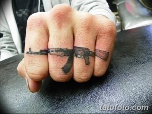 Фото тату на пальцах: три автомата Калашникова, расположенных на разных пальцах руки. Оригинальный и смелый рисунок татуировки.