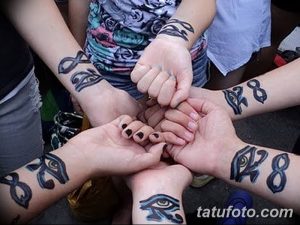 Фото парных татуировок глаза Гора, выполненных в сине-серых тонах на запястьях нескольких людей. Идеально для группы друзей, разделяющих общие ценности.