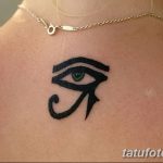 Фото тату на затылке: маленький, стилизованный Глаз Гора в черном цвете. Минималистичный дизайн, аккуратные линии.