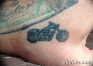 Фото тату: небольшая татуировка мотоцикла, выполненная на руке в черном цвете. Стильный эскиз тату для байкеров.