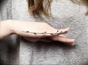 Фото тату: тонкая, изящная веточка с листьями, выполненная на руке в технике тонких линий. Прекрасный эскиз тату для любителей флористики.