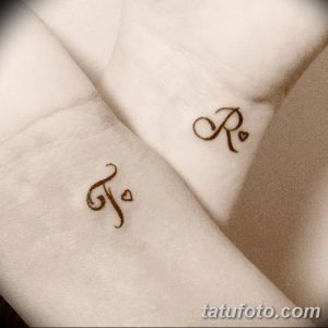 Фото парных тату на запястьях: буквы 'J' и 'R' с сердечками. Маленькие, минималистичные рисунки татуировок в черном цвете.