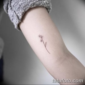 Фото тату: маленький цветок с тонкими линиями на предплечье. Изящный и минималистичный рисунок татуировки в черном цвете.