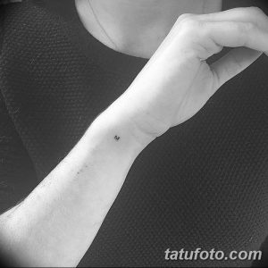 Фото минималистичной татуировки с одной буквой 'M' на запястье. Простой и лаконичный рисунок, выполненный черными чернилами.