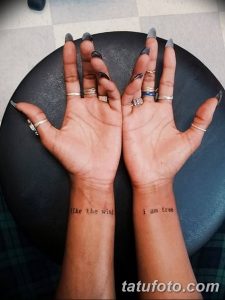Фото парных татуировок на запястьях с надписями 'like the wind' и 'i am free'. Черно-белые татуировки, символизирующие свободу и легкость.