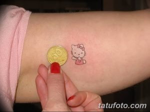 Фото тату Hello Kitty на внутренней стороне предплечья. Маленький, нежный рисунок в пастельных тонах, выполненный тонкими линиями. Идеально для поклонников аниме.