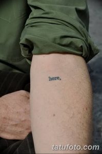 Фото тату: Минималистичная надпись 'here' на предплечье, выполненная простым шрифтом. Черно-белая татуировка небольшого размера.