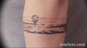 Фото тату: минималистичная татуировка в виде горизонтального пейзажа с воздушным шаром на руке. Черно-белый рисунок, выполненный точками.