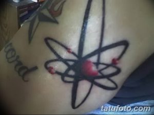 Черно-белая татуировка атома на плече, выполненная в минималистичном стиле. Простой и лаконичный рисунок тату для любителей науки.