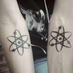 Фото парных татуировок на предплечьях: два одинаковых рисунка атомов, выполненных в черном цвете. Идеи для парных тату.