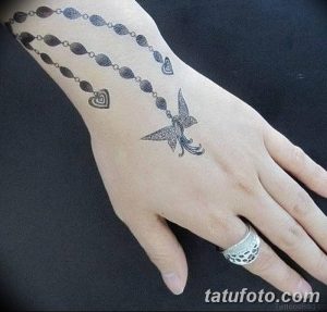 Фото тату: небольшая татуировка с изображением летящей ласточки и нити бус на руке, выполненная в минималистичном стиле.